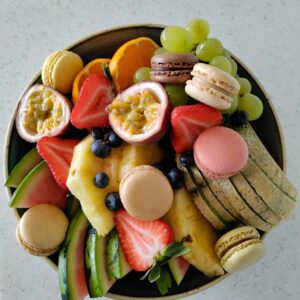 Kulho täynnä erilaisia paloiteltuja hedelmiä.